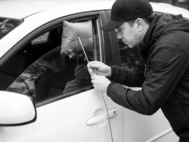 Locksmith opening a locked white car door with an air wedge and long-reach tool
