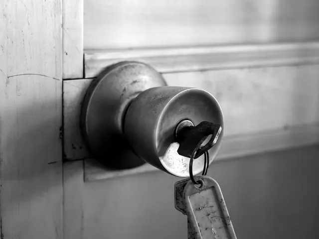 Worn metal door knob with a key and tag left in the lock