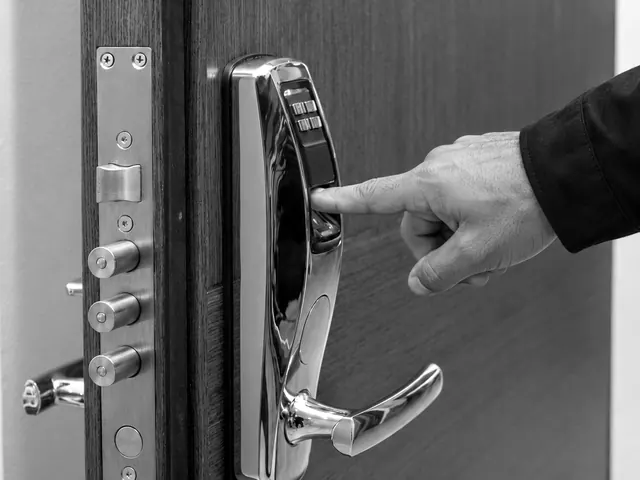 Finger on the fingerprint reader of a smart lock fitted to a door