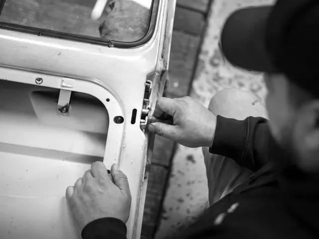 Technician working on a car door lock latch